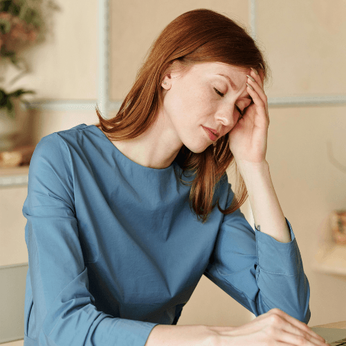 Mamma preoccupata con mano alla fronte ed occhi chiusi