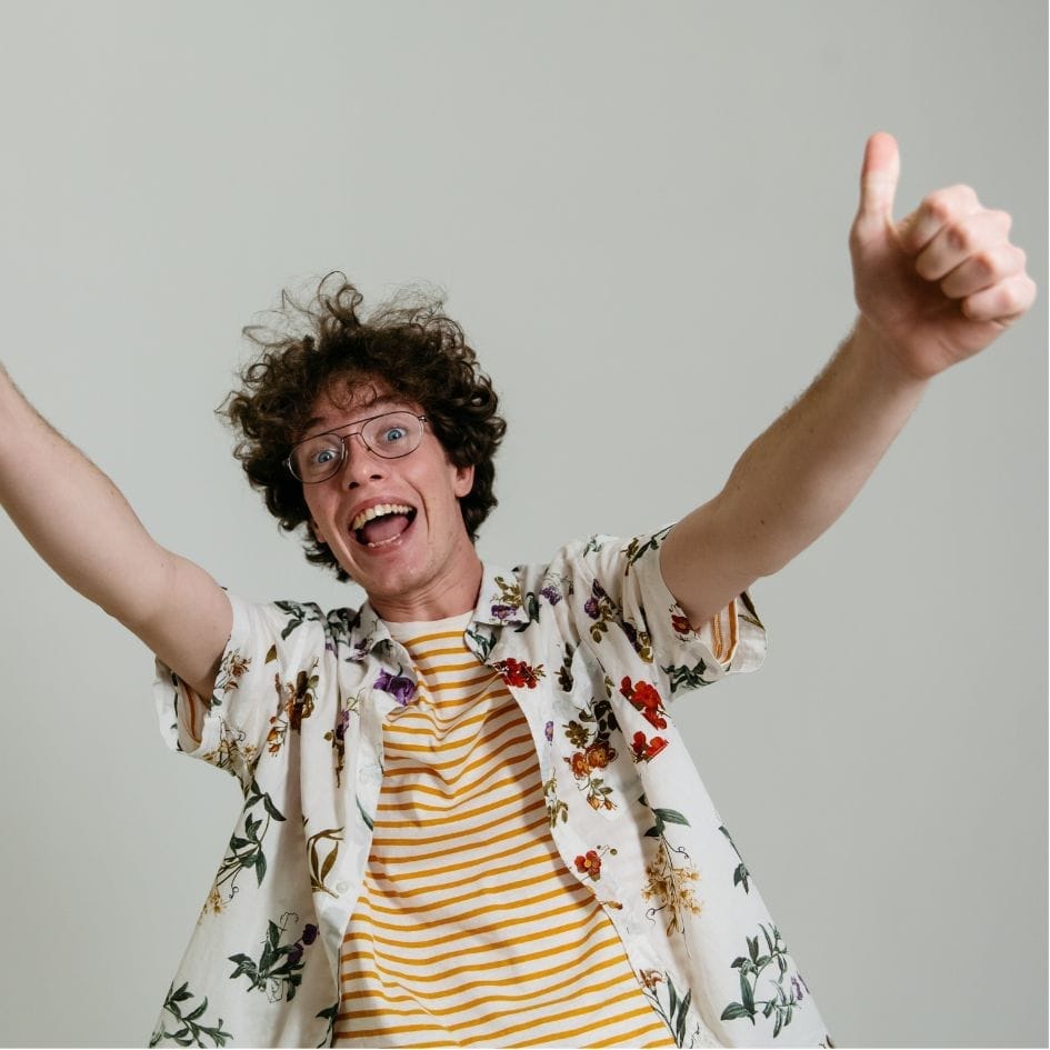 Ragazzo felice con pollici alzati in segno di successo nello studio