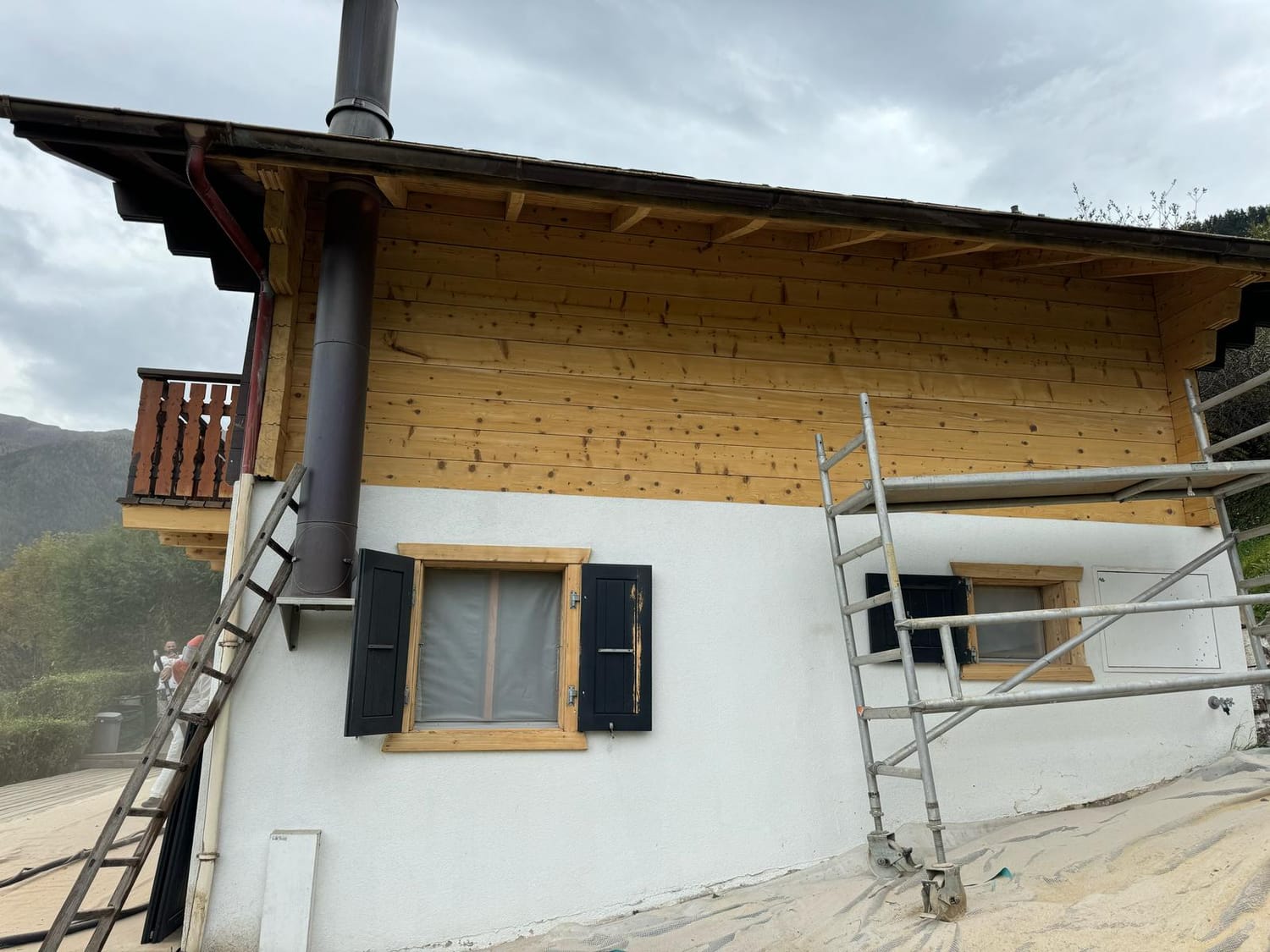 Traitement du bois en cours sur la façade du chalet
