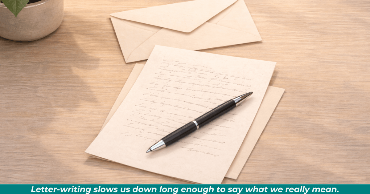 A handwritten letter, envelope, and pen on a desk, symbolizing the quiet art of letter-writing.
