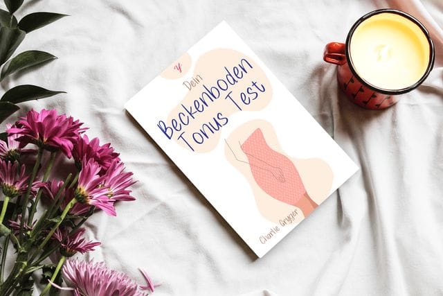 Buch Beckboden Tonus Test auf weisser Decke, Blumen liegen links davon, eine Tasse Kaffee rechts davon