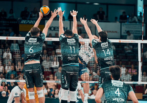 Drei Volleyballspieler inklusive Mittelblocker Michael Andrei springen zum Block hoch.