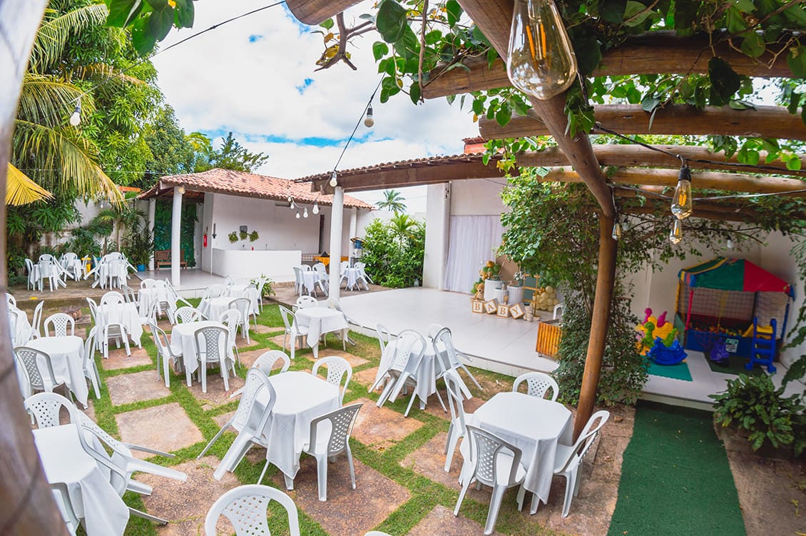 espaço sombra com mesas e cadeiras brancas