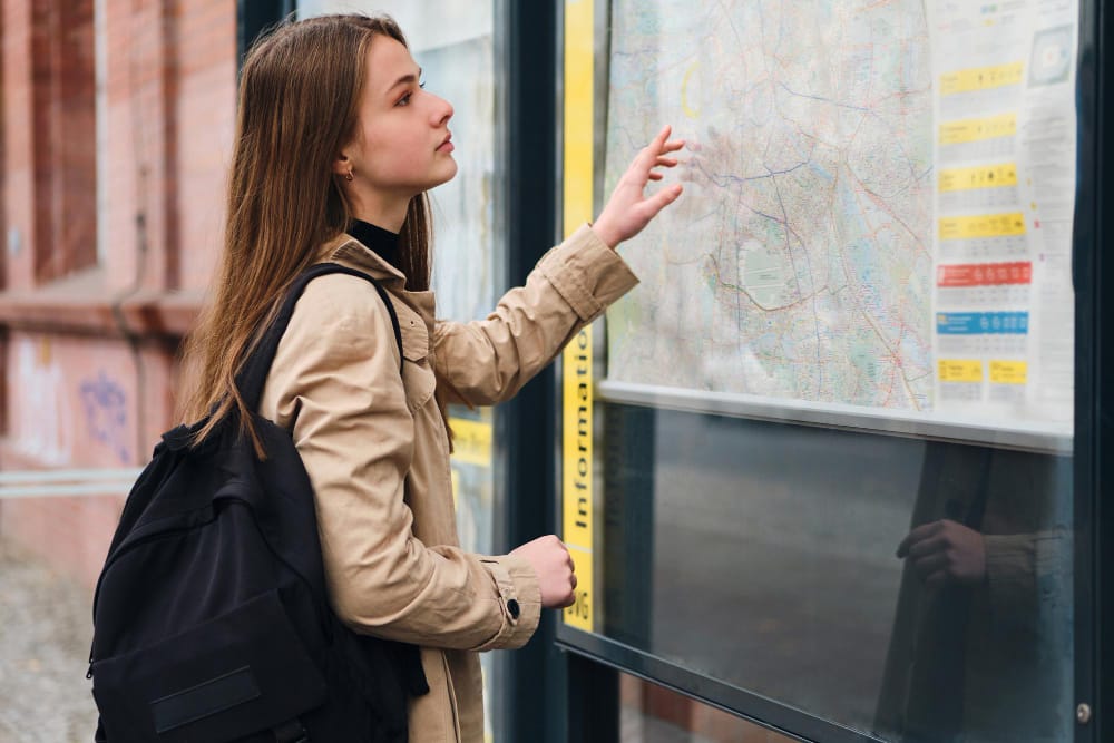 Young woman making a choice about where she is going on a city map