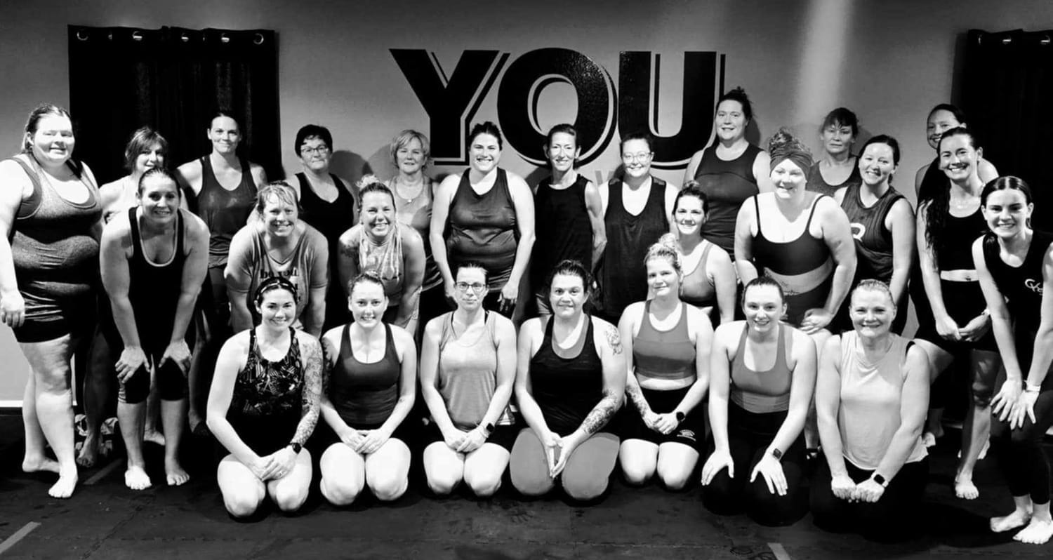 Yoga class in a dark-lit studio glowing with purple LED lights at Crystallyn Kay’s Studio