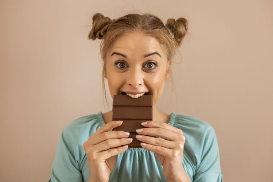 Jeune femme qui mange du chocolat