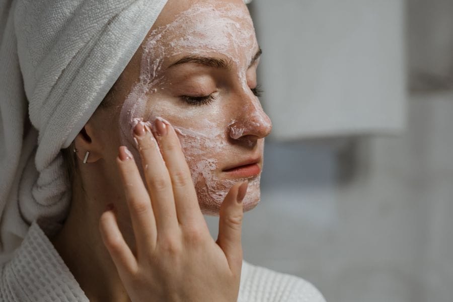 Femme applique masque à l'argile rose