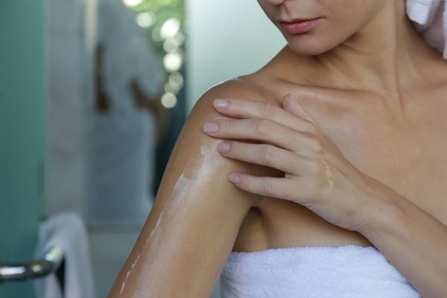 Femme applique crème sur bras
