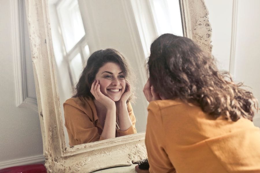 Femme qui se regarde dans le miroir