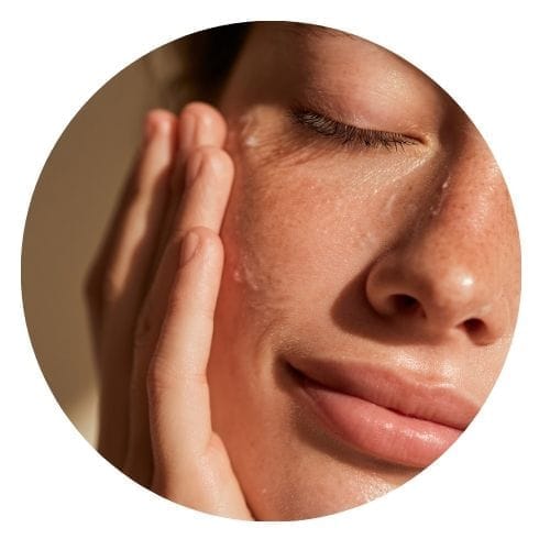 Femme qui applique un soin sur son visage