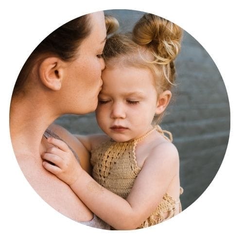 Maman qui embrasse le front de sa petite fille