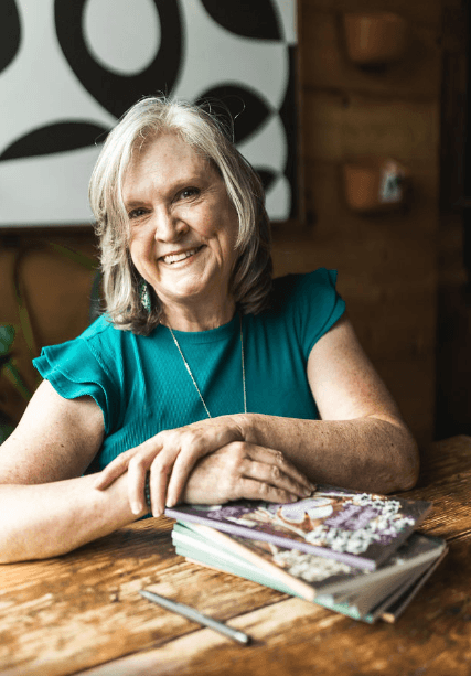 Coach smiling confidently with a laptop open on her lap, ready to work with a client