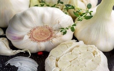 A képen félbevágott, és egész, magas allicin tartalmú fokhagymafejek vannak. fokhagyma