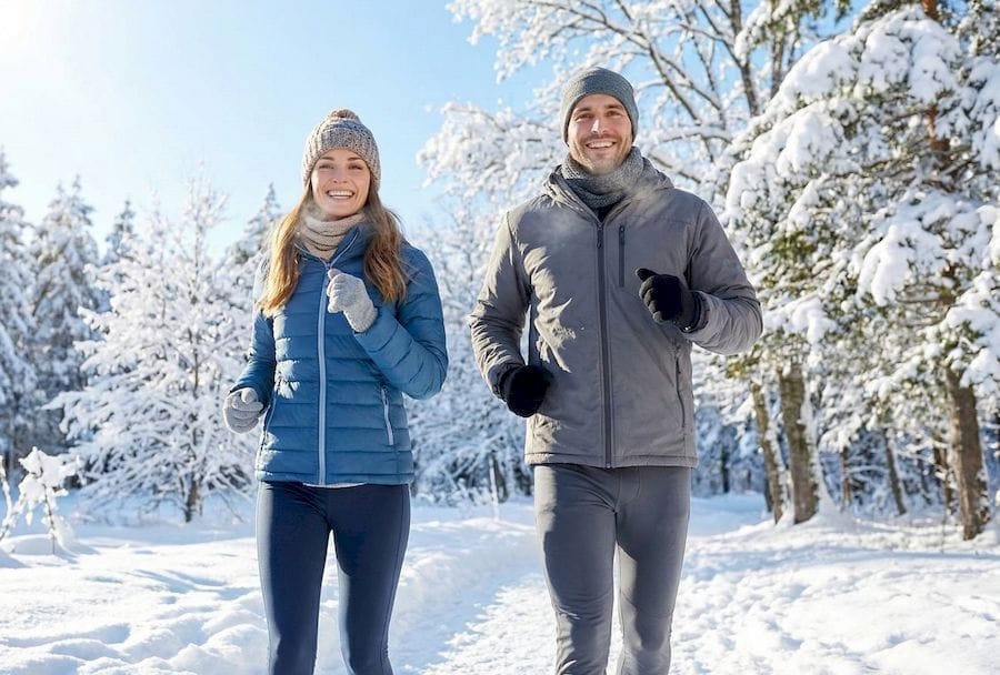 Fiatal pár fut a szép téli tájon, testmozgás a májregenerálás érdekében..