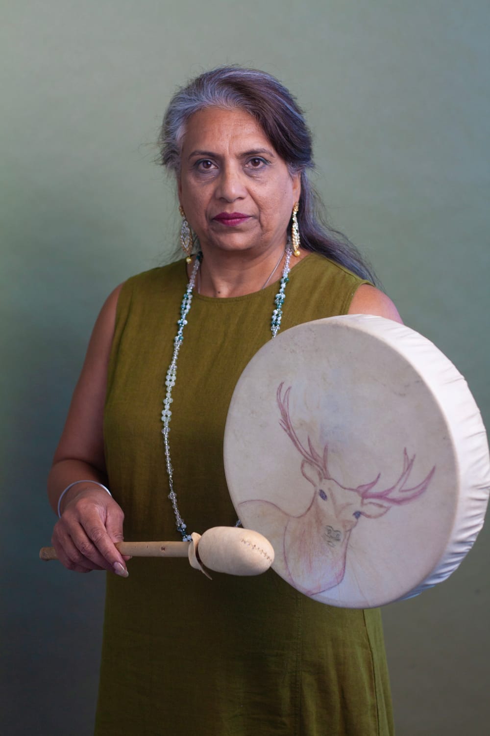 Harjit seated with a drum, facing forward