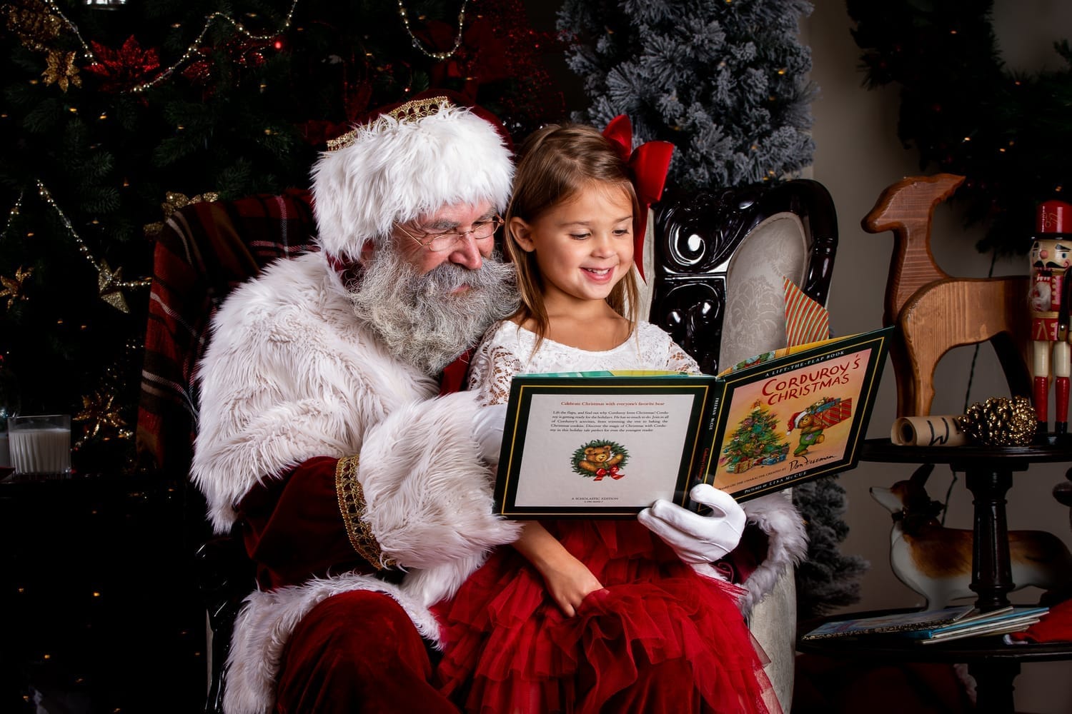 little boy with santa reading the nice list in his parlor in downtown meridian idaho