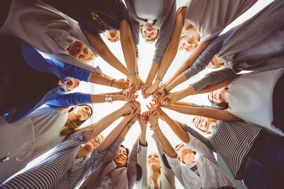A circle of people joining hands in community
