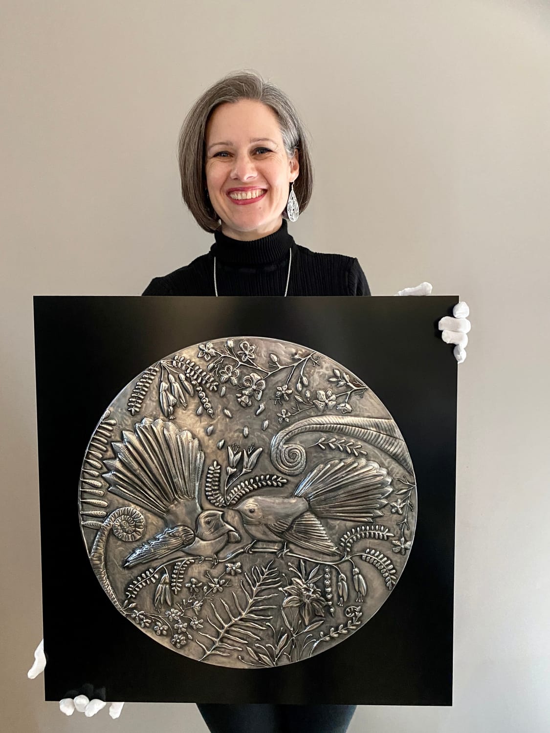Professional pewter artist Ninette Kruger with embossed metal bird art