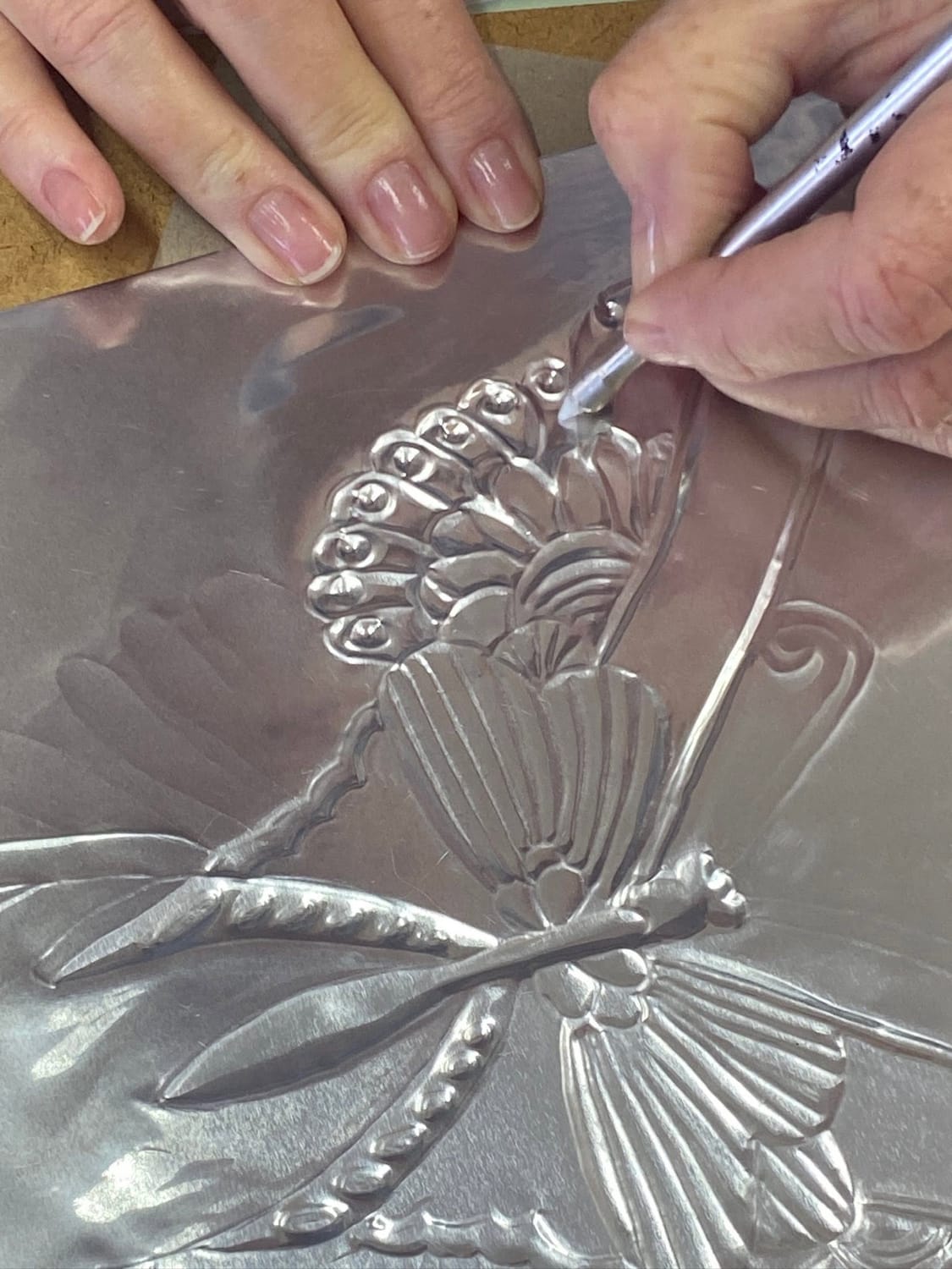 Hand-embossed metal butterflies and dragonflies featured in a beginner metal embossing workshop at Te Puna Quarry Park near Tauranga, New Zealand.