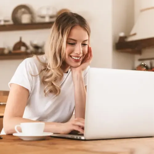 A relaxed woman working on a laptop with a smile