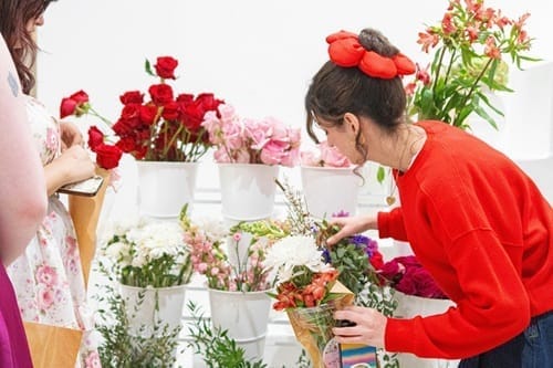 Fleuriste souriante en boutique, en plein travail pour renforcer sa visibilité locale