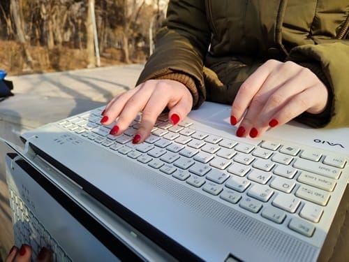 Mains féminines tapant sur un clavier d’ordinateur lors d’un accompagnement digital personnalisé