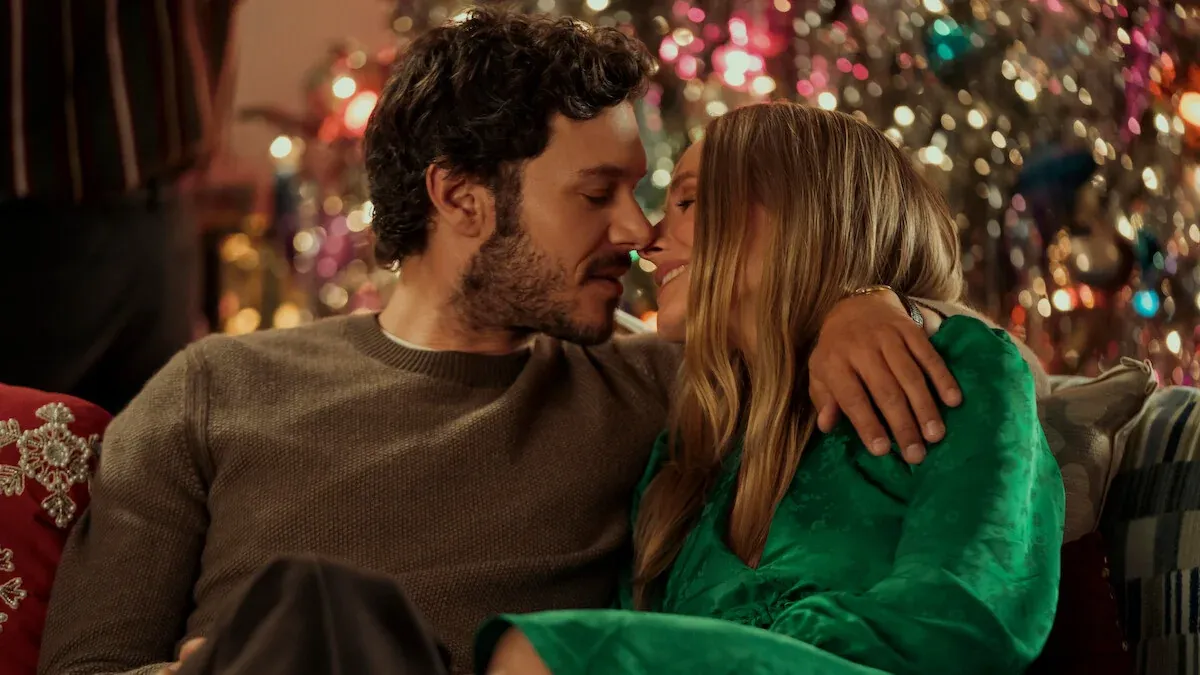 Joanne e Noah abbracciati sul divano davanti all'albero di Natale illuminato, in Nobody Wants This 3