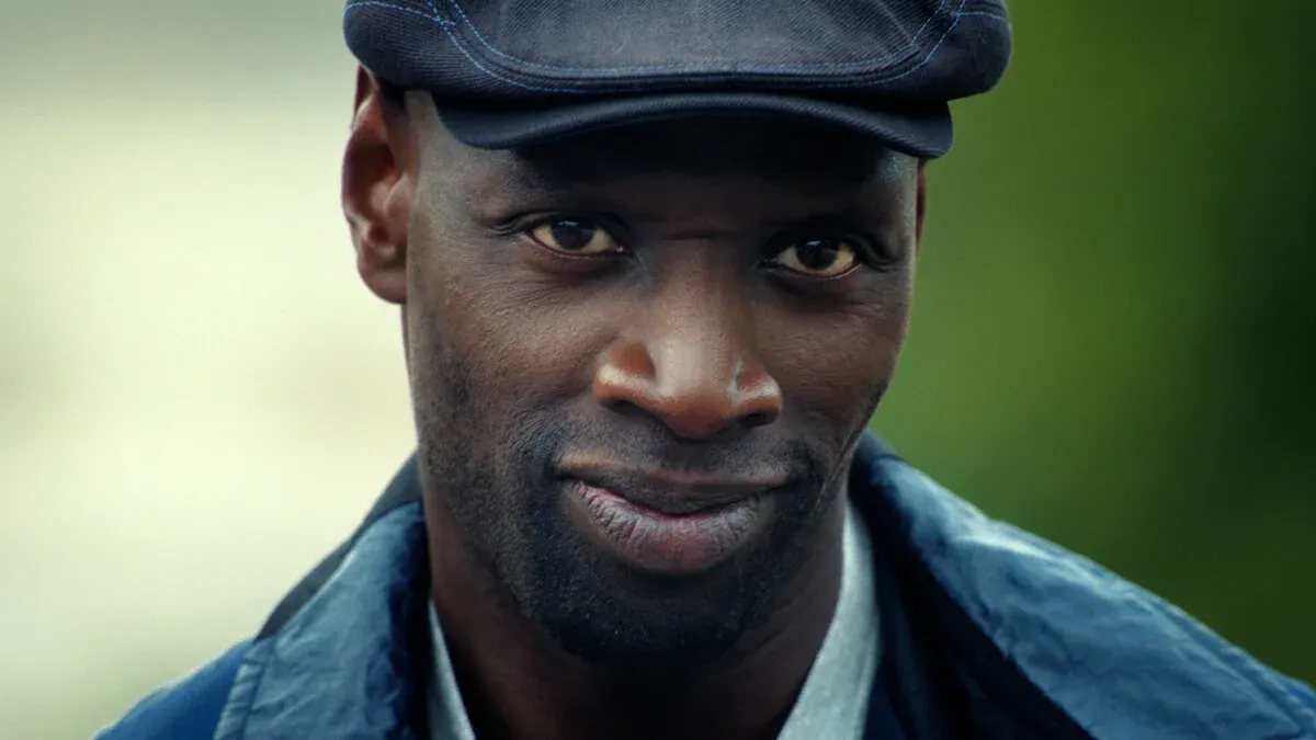 Primo piano di Omar Sy con la coppola nei panni di Assane Diop in Lupin