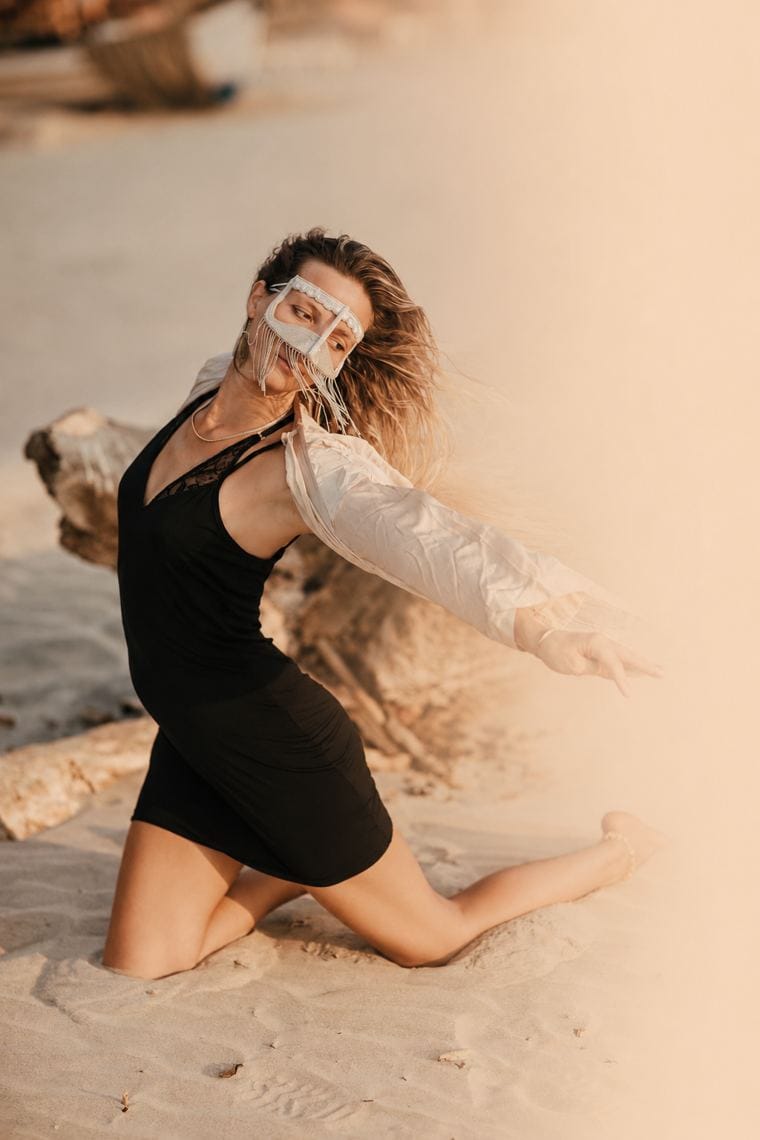 Frau tanzt barfuß im Sand