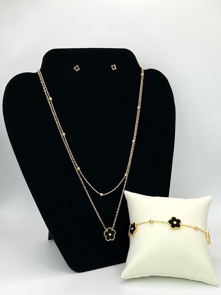 Parure de bijoux en acier inoxydable doré avec détails de fleurs noires : collier double, boucles d'oreilles et bracelet assorti
