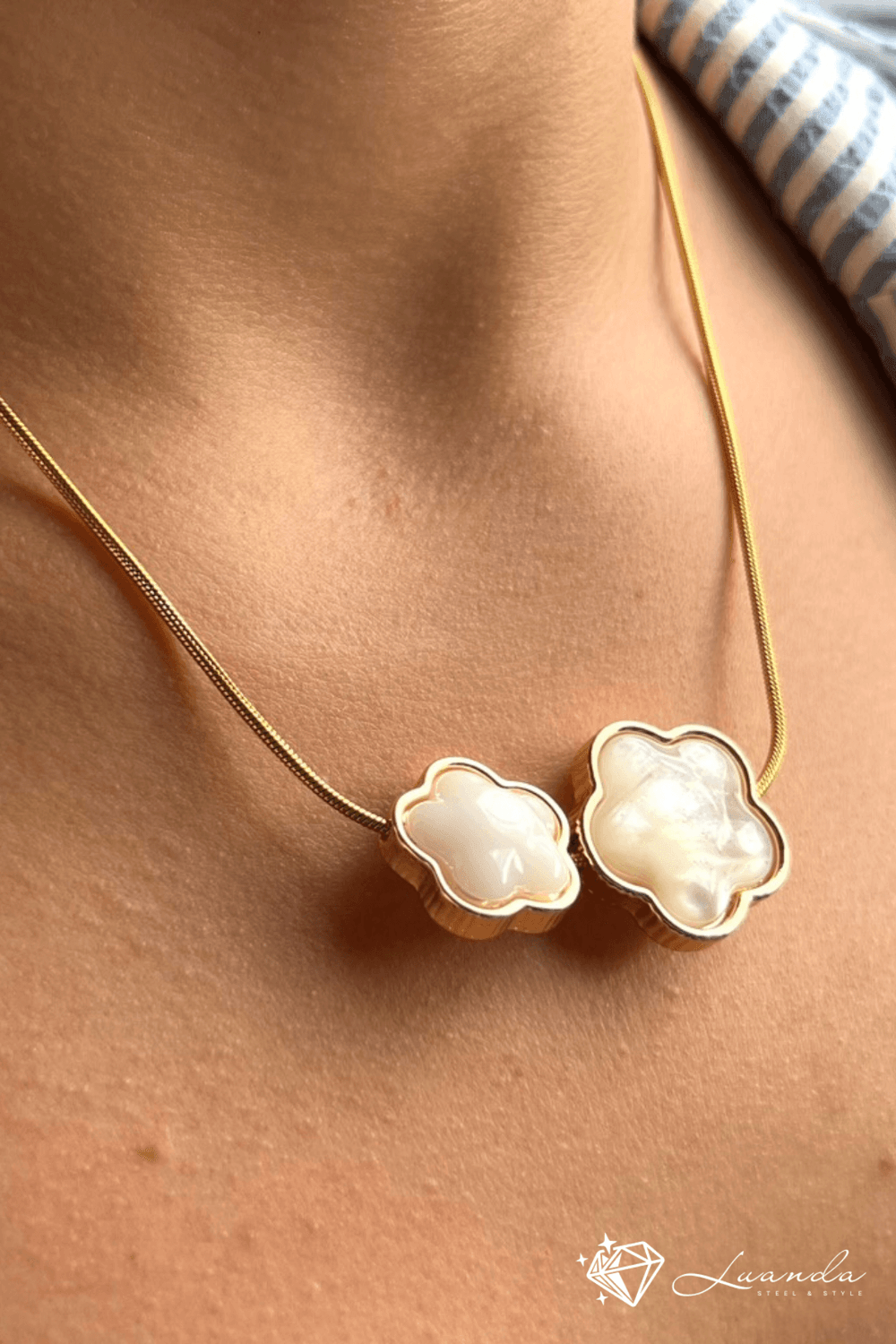 Collier en acier inoxydable avec breloques en forme de fleur en nacre blanche, porté autour du cou – Luanda Steel & Style