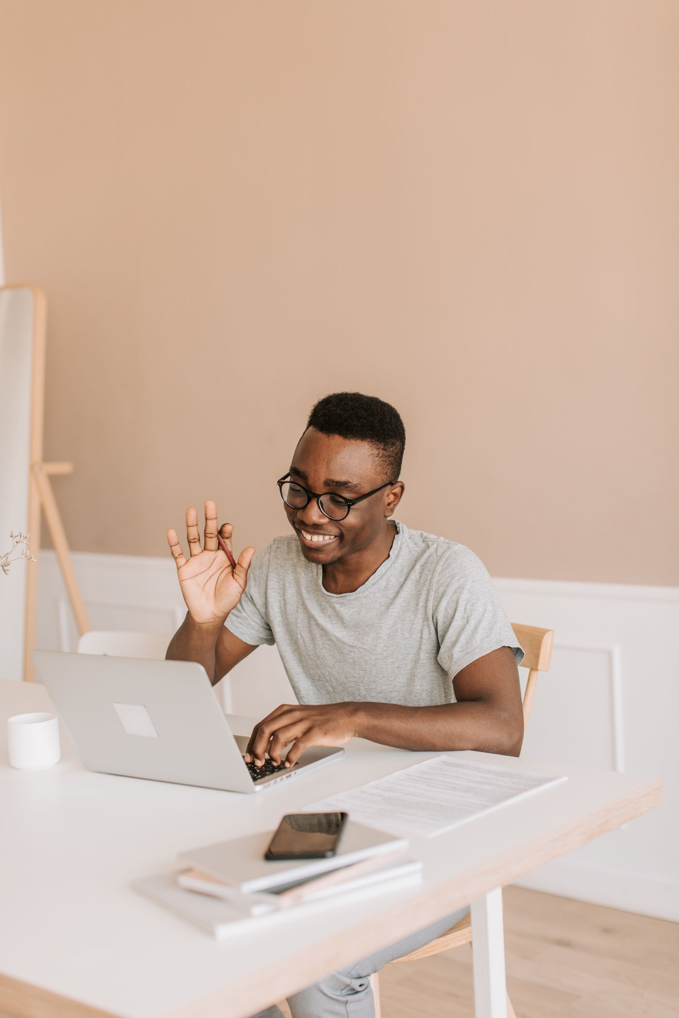 Homme souriant en visioconférence devant son ordinateur portable