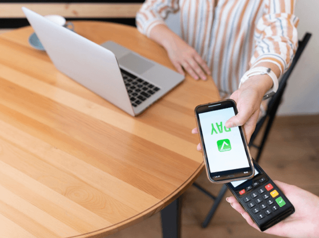 "Femme réalisant un paiement sécurisé depuis son smartphone sur un terminal de paiement"