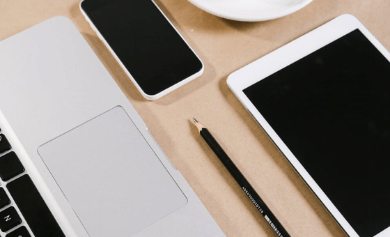 "Bureau avec ordinateur portable, tablette, téléphone et crayon"