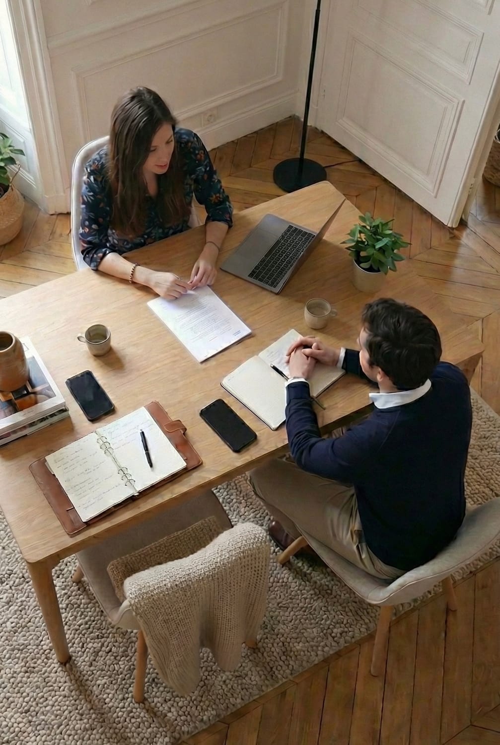 "Vue d'en haut d'un bureau où l'on voit Sarah et un client en pleine consultation"