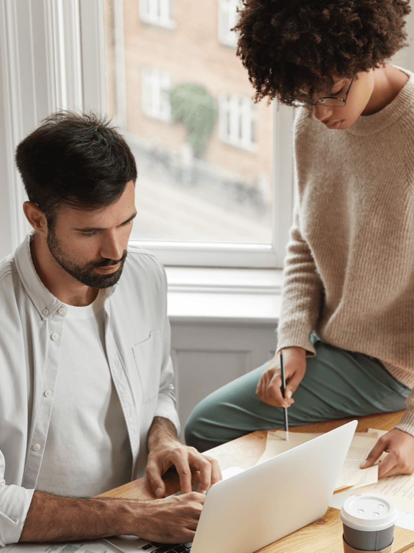 "Vue de deux entrepreneurs travaillant ensemble sur un ordinateur portable et des documents"