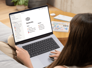 "Femme de dos avec ordinateur ouvert sur une page Notion"