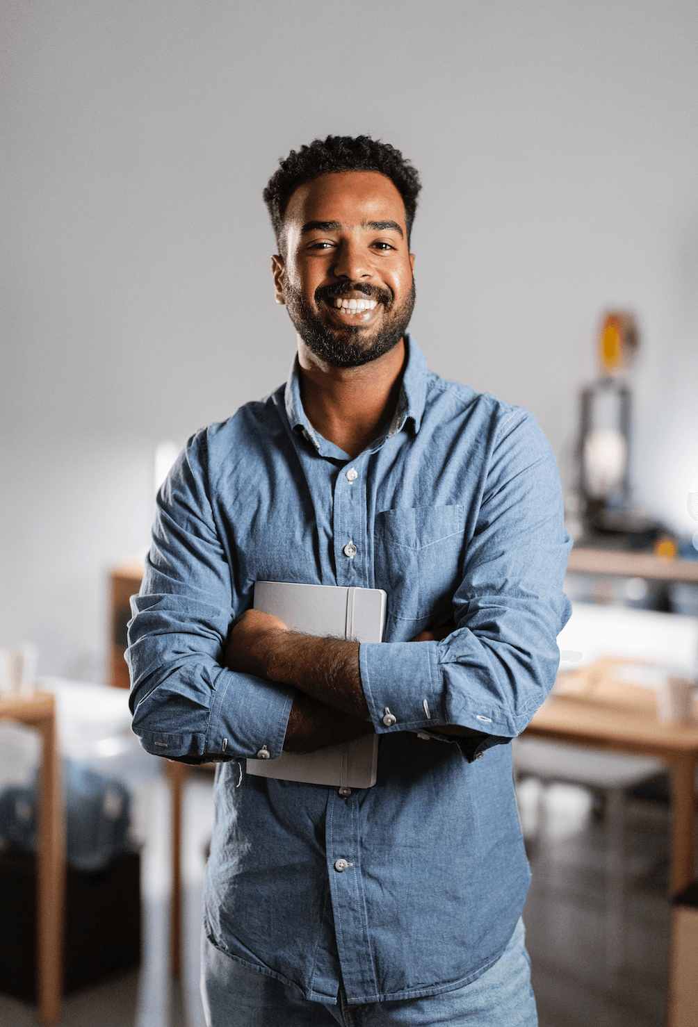 "Homme quinquagénaire souriant, assis sur un canapé avec un carnet à la main"