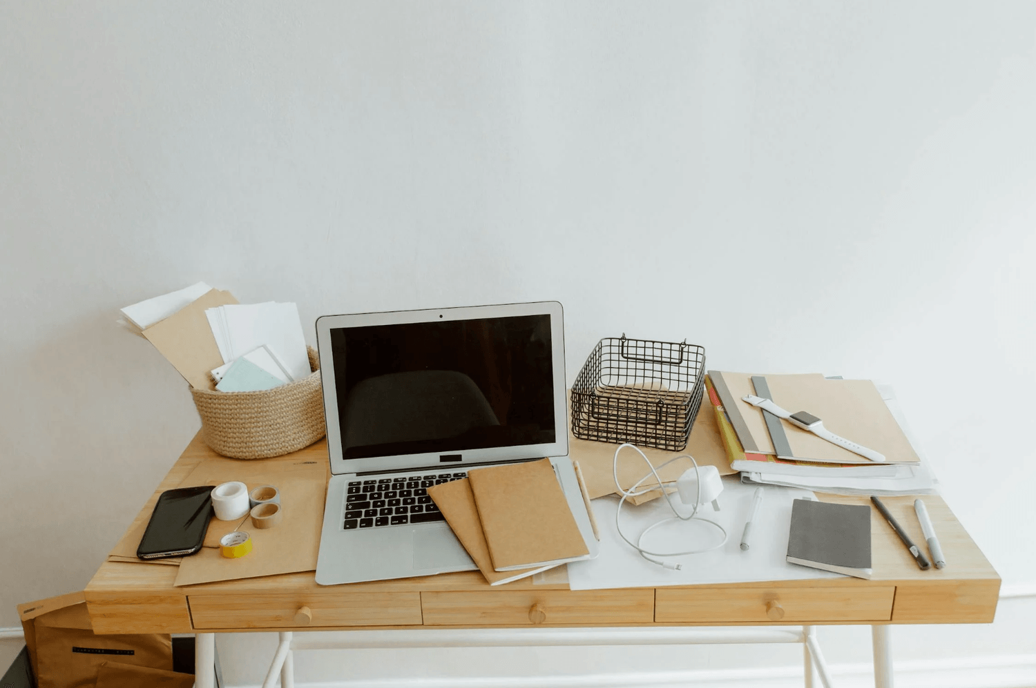 alt="Espace de travail d'un indépendant, en désordre, illustrant la réalité de l'organisation entre outils numériques et notes papier"