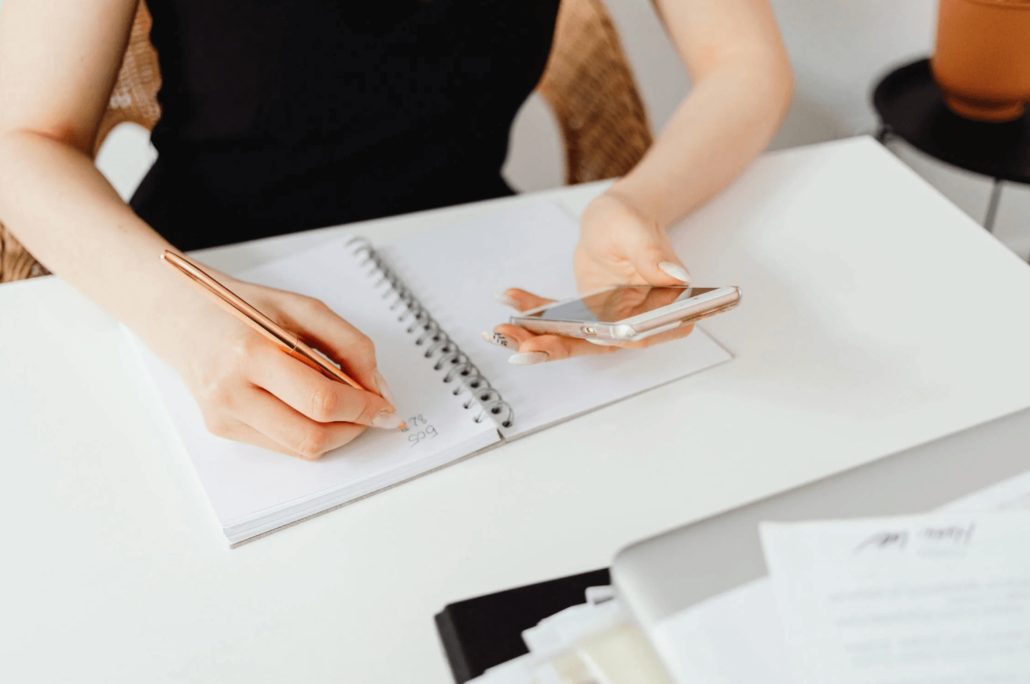 alt="Solopreneure en pleine comptabilité de son activité, jonglant entre la prise de notes manuscrites et la calculatrice de son smartphone"