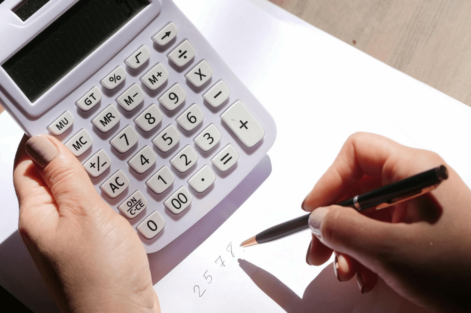 alt="Indépendant faisant ses comptes et calculant le juste prix de ses offres à l'aide d'une calculatrice"