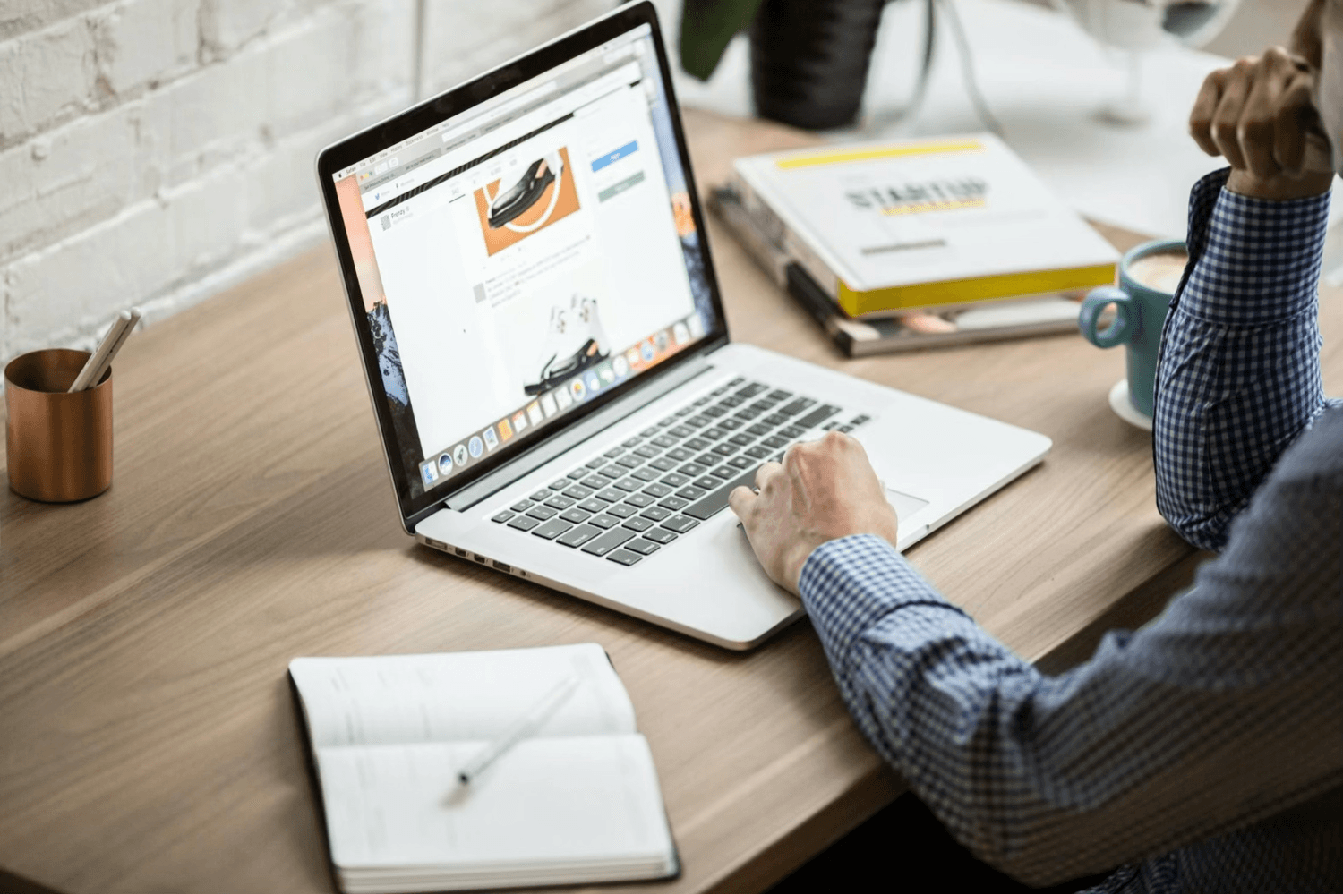 alt="Entrepreneur analysant la stratégie de communication à adopter pour promouvoir son activité, depuis son bureau"