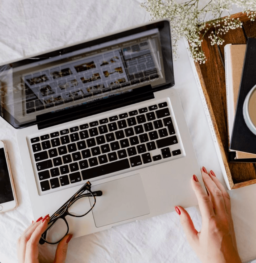 alt="Deux personnes se font un check du poing au-dessus d'une table en bois où sont posés deux ordinateurs portables ouverts face à face"
