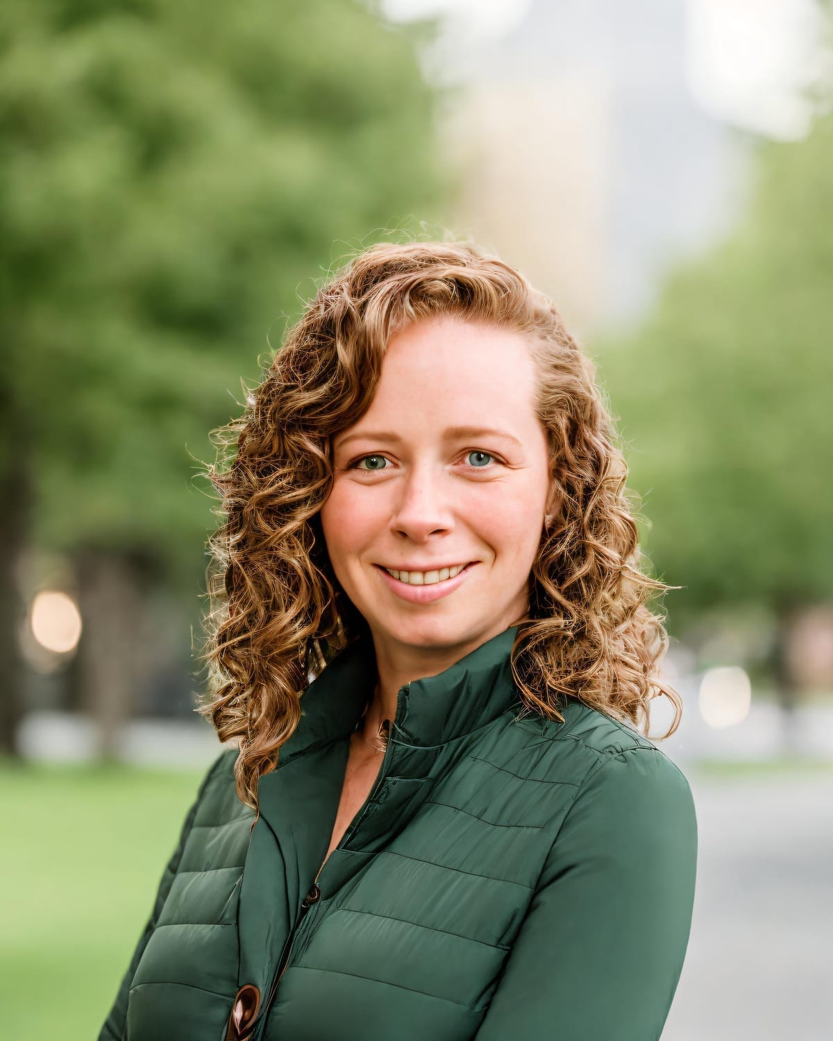 Marie Rivera, virtual assistant, smiling outdoors in professional green jacket.