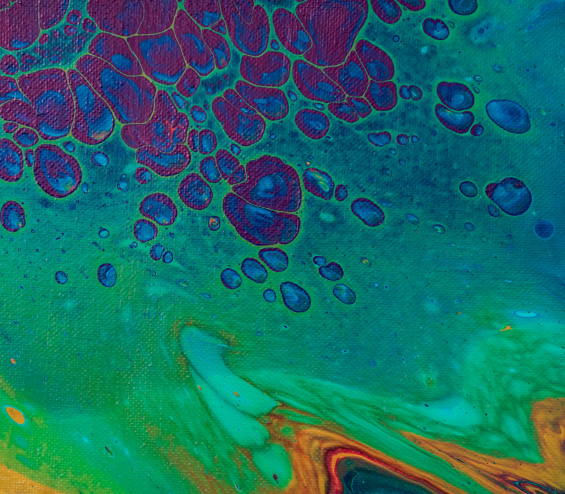 Acrylic pouring painting of blue bubbles against green background