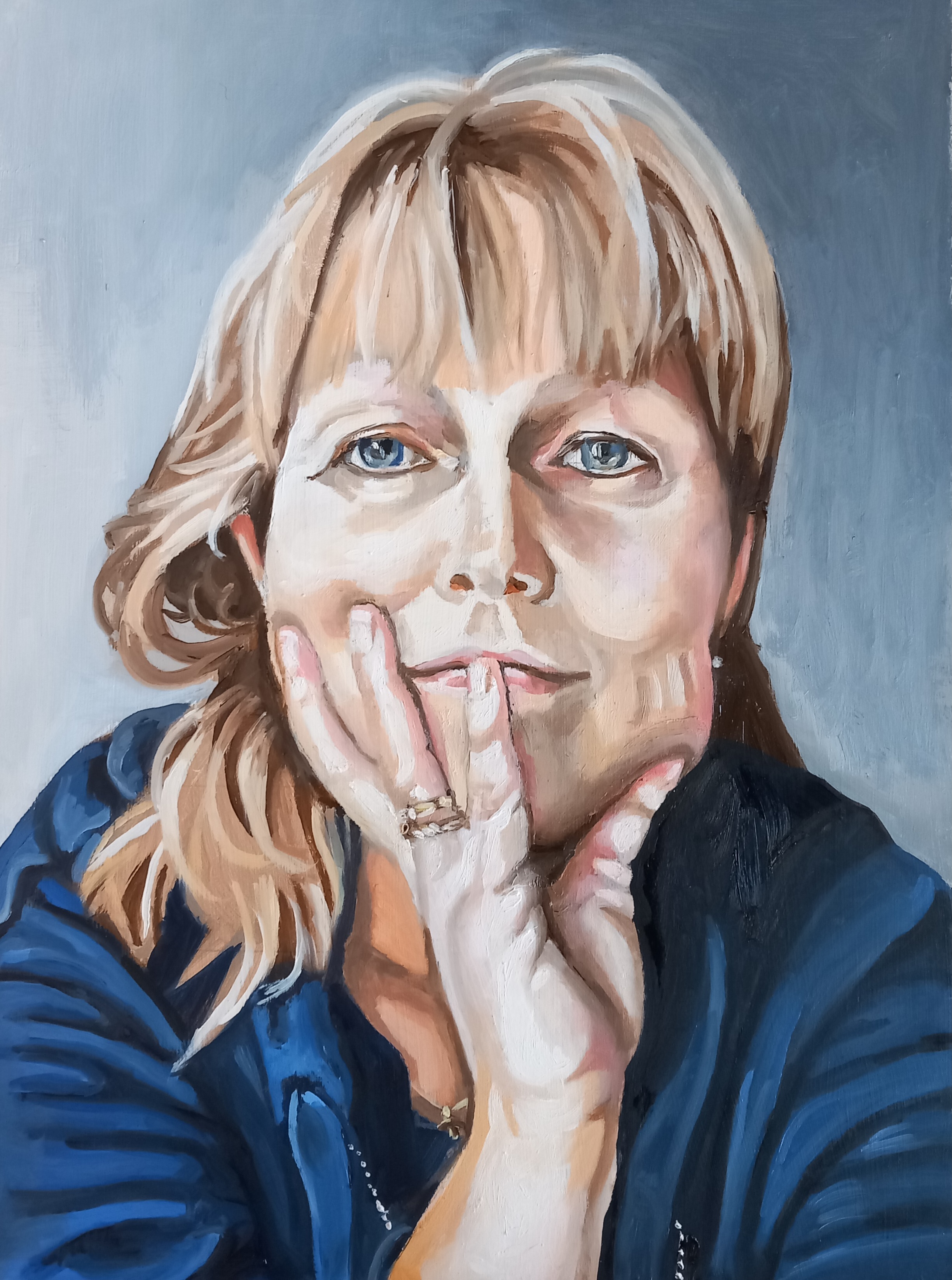 Oil painting of Tineke Tammes, a blond woman in a blue hoodie against a grey background