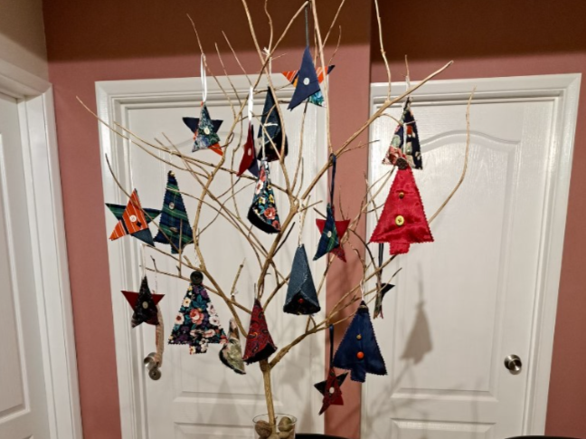 Little Christmas Trees made of material hung on branches