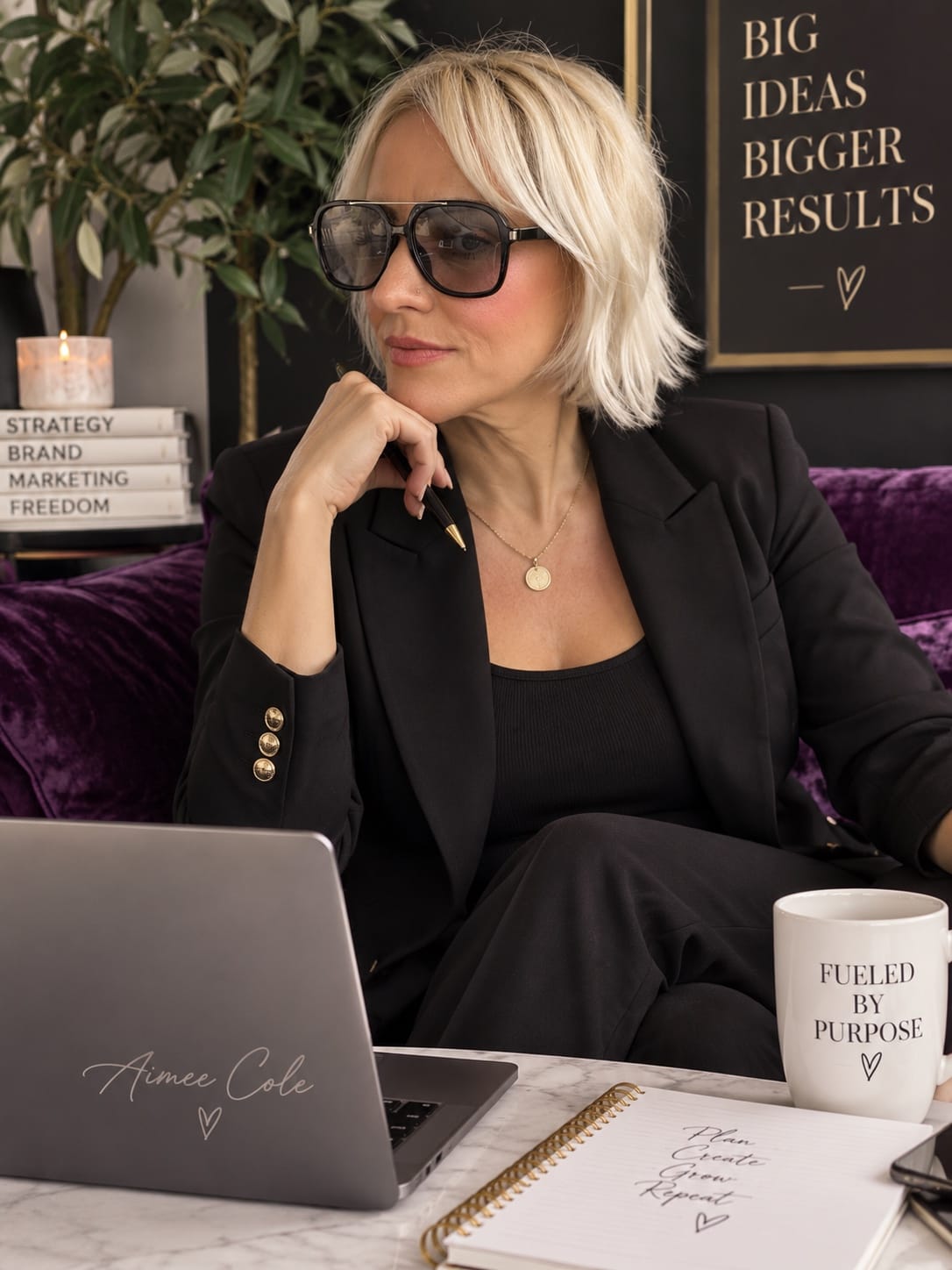 Aimee Cole at her desk with her laptop and notebook