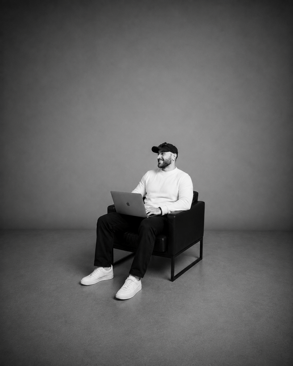 Kadir Demir im Studio mit Laptop auf einem Sessel