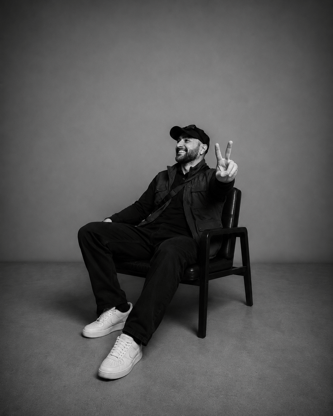 Kadir Demir im Studio sitzend mit Peace-Zeichen